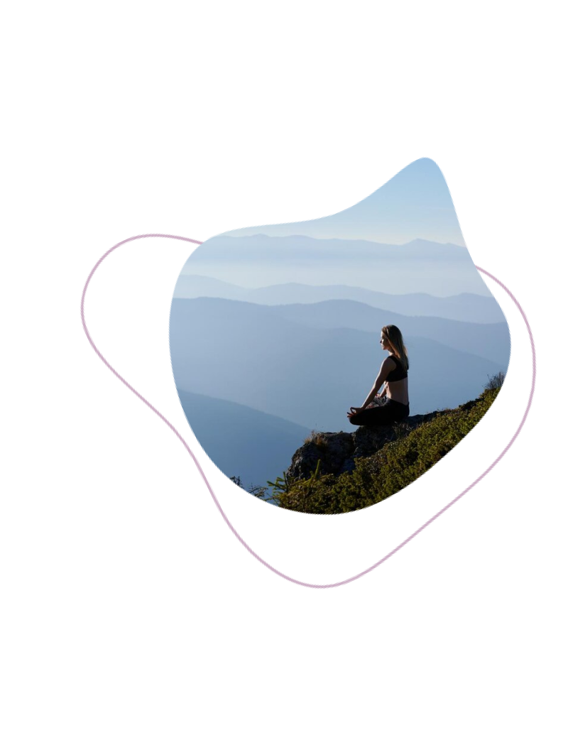 Femme assise à flanc de montagne, regardant au loin.